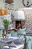 Covered terrace with fireplace, brick wall and spring decorations
