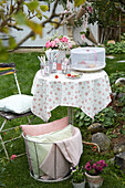 Spring coffee table with floral tablecloth in the garden
