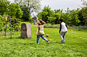 Children playing football on a green field
