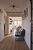 Langer Flur mit Holzboden moderner Bank mit Polster und Deckenleuchte im Retro-Stil