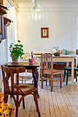 Rustic café with wooden furniture, patterned cushions and white panelling