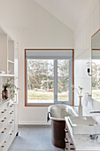Bathroom with free-standing bathtub in a modern country house style with a view of nature