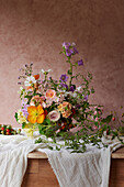 Magnificent bouquet of roses (Rosa) and bellflowers (Campanula) on a wooden table