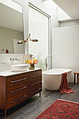 Free-standing bathtub and washbasin in the daylight bathroom