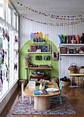 Creative craft room with wooden table, children's chairs, shelves and colourful decorations