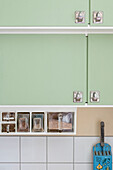 Green kitchen cabinets with practical storage containers