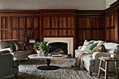 Historic living room with wooden wall panelling and classic upholstered furniture
