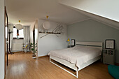 Bedroom with wooden floor and sloping ceiling