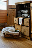 Rustic wooden cabinet with grey towels and cushions