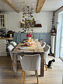 Rustic wooden table in the dining room with autumn decorations and cat