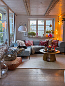 Cosy living room with wooden ceiling and colourful cushions on a light blue sofa