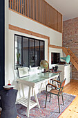 Work area with glass table and vintage decorative objects in front of a brick wall