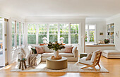 Spacious living room with cream-coloured sofa and large windows