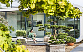 woman sitting on a terrace with an iPad, coodo modern way of living, modern architecture in Hamburg, north Germany, Germany