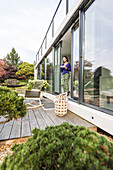 Frau steht an einer Terrassentür mit einer Tasse, coodo moderne Art zu Wohnen, moderne Architektur in Hamburg, Hamburg, Norddeutschland, Deutschland