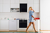 Woman walking in modern kitchen