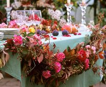 Garland of roses, rose hips and hydrangeas as table decoration