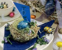Nest with blue Easter egg and place card