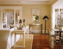 Pale living-dining room in white and natural shades with vintage, country-house-style decor