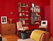 Retro interior with 70s wall-mounted shelves and deer's head sculpture against bright red wall