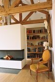 Interior with exposed roof structure, bookcase and open fireplace