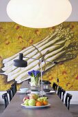 Long dining table, chairs, large painting of asparagus and elliptical lamp
