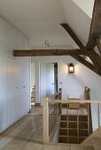 Landing with wooden board floor, fitted cupboards and rustic roof beams