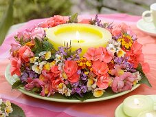 Wreath of summer flowers around candle