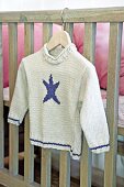 Child's knitted jumper on coat hanger