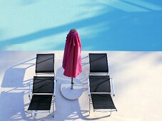 Sonnenliegen und Sonnenschirm am Swimmingpool