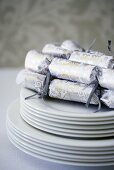 A stack on plates with Christmas crackers on top