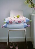 Coloured pillows with a pear on chair