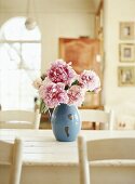Peonies in a vase on a kitchen table