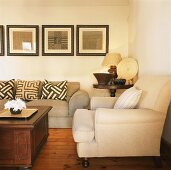 Wohnzimmer mit Couchgarnitur und Holztisch vor Bildersammlung an der Wand