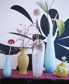 Fünf verschiedene Glasvasen mit einzelnen Blüten