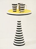 Black and white striped mugs on small table