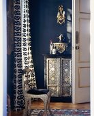 Prunkvolle Kommode und Stuhl in einer Zimmerecke mit blauen und goldenen Akzenten