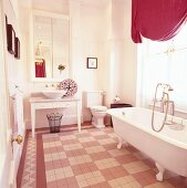 Romantisches Badezimmer in Rosatönen mit 50er Jahre Waschtisch und freistehender Badewanne