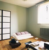 Wohnraum im japanischen Stil mit Futon und Paravent