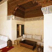 Sitzecke eines orientalischen Innenraums mit prunkvoller Decke