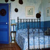Ein Schlafzimmer mit Metallbett in einem traditionellen Landhaus