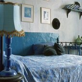Ein Metallbett in einem blauen, traditionellen Schlafzimmer