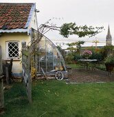 Kleines Bauernhaus mit Glasanbau neben der Terrasse