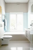 Weisses Badezimmer mit eingebauter Badewanne und glänzendem Steinboden