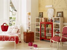 Kinderzimmer in Rot- & Weisstönen mit Metallbett, Wandregal, Polsterstuhl & Spielzeugkiste