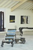 Showroom eines Kunstschmiedes mit verschiedenen Metallmöbeln & modernen Wandgemälden