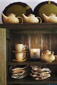 Geschirrschrank mit asiatischen Teekannen, Tassen & Tellern (Ausschnitt)