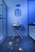 Bläulich beleuchtetes Badezimmer mit Mosaikfliesenboden & maritimer Deko