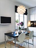 Küche in Weiß und Schwarz mit Esstisch, Küchenstühlen, Fernseher & moderner Deckenleuchte