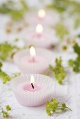 Tealights in muffin cases, lady's mantle and chamomile